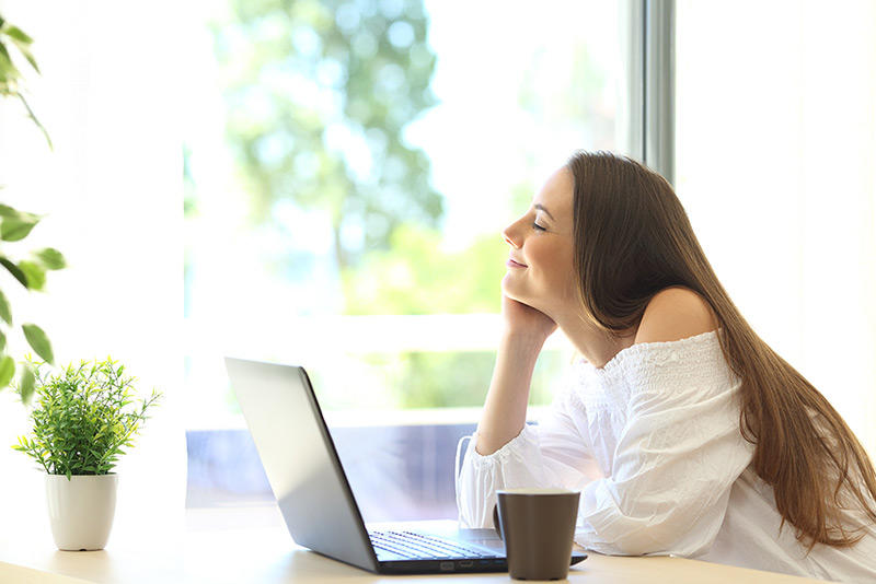 relaxed woman sitting in her house and smiling