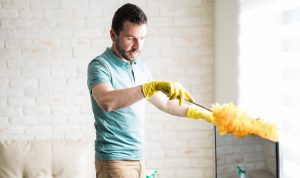 young man dusting a house
