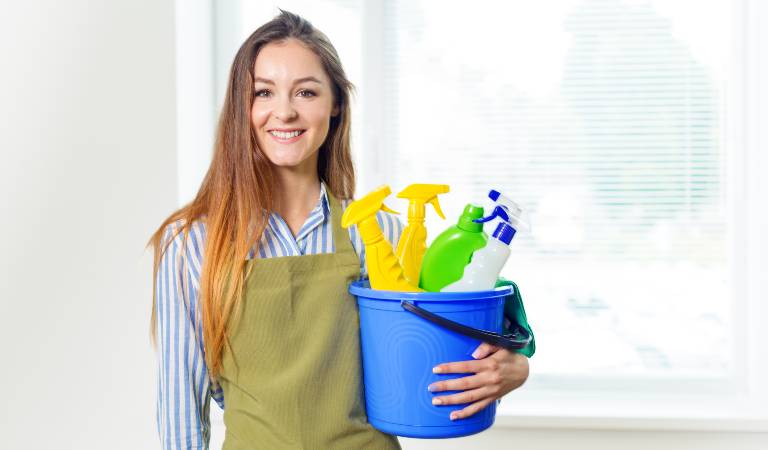 Woman holding a blue basket filled with tools and supplies
