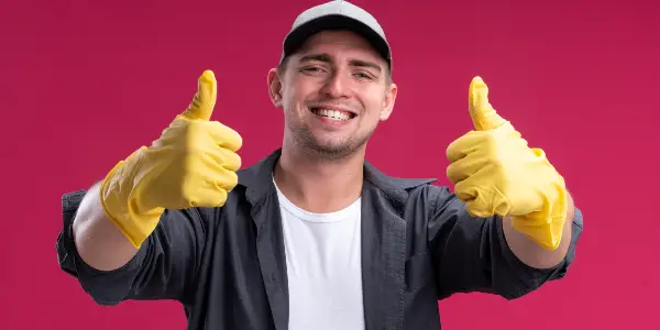 Man in black shirt and cap showing thumps up.