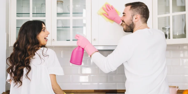A couple is cleaning cabinets.