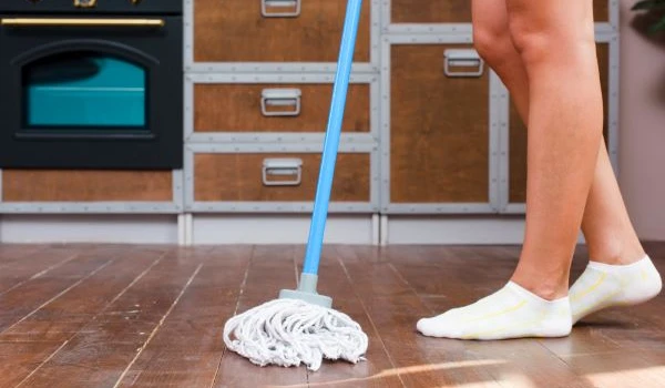 cleaner mopping floor in kitchen