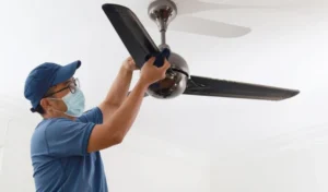 A man Cleaning Ceiling Fan
