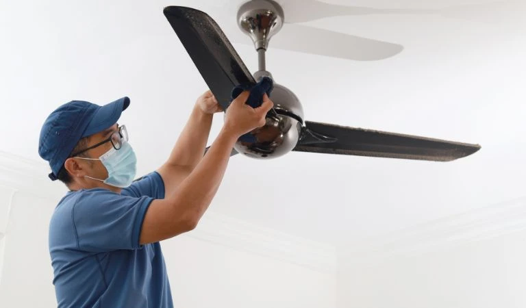 A man Cleaning Ceiling Fan