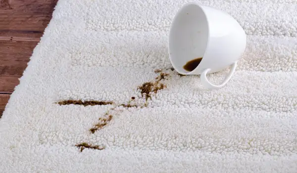 Coffee spilling from cup on carpet. Domestic life. The concept of cleaning stains
